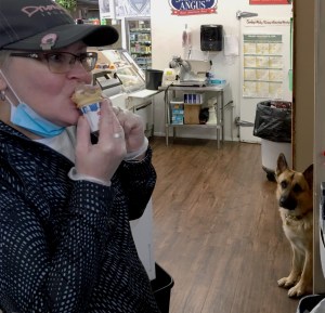 Dog watching Kelly eat an ice cream cone