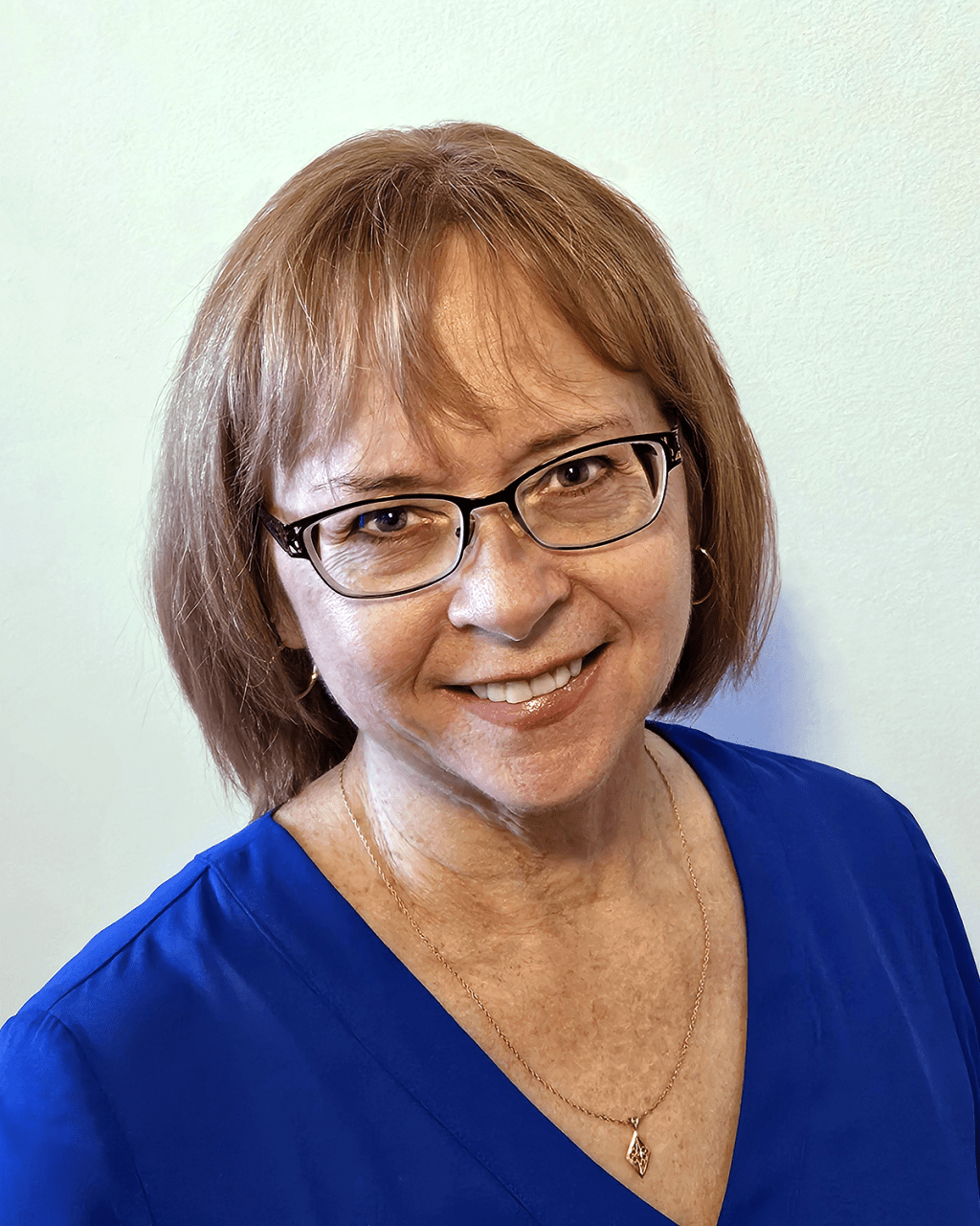 Carlene MacGregor in a blue blouse, smiling.